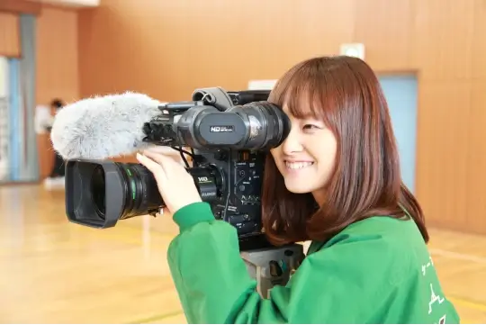 K.N.が撮影用カメラを担いで覗いている写真